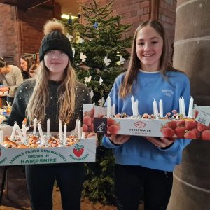 Picture of two teenagers holding the Christingle that they made